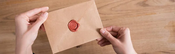 Top view of craft paper envelope with wax stamp in hands of cropped notary, banner — Foto stock