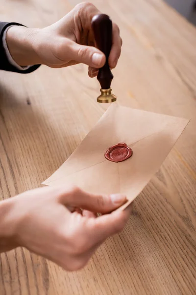 Vista recortada del notario con sello y sobre de papel artesanal con sello de cera - foto de stock