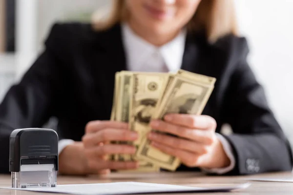 Selective focus of stamper near cropped notary counting dollars on blurred background — Photo de stock