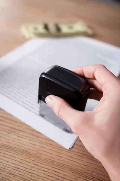 Ausgeschnittene Ansicht des Notars mit Stempel in der Nähe verschwommener Vertrag und Geld — Stockfoto