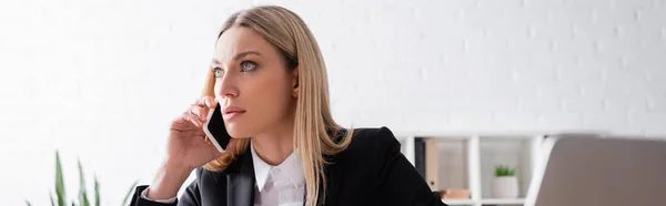 Blonde lawyer looking away while talking on smartphone, banner — Foto stock
