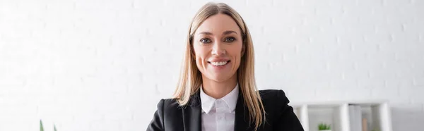 Cheerful blonde notary looking at camera in office, banner — Foto stock