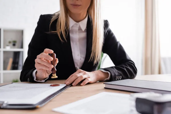 Cropped view of notary holding stamper near documents — Foto stock