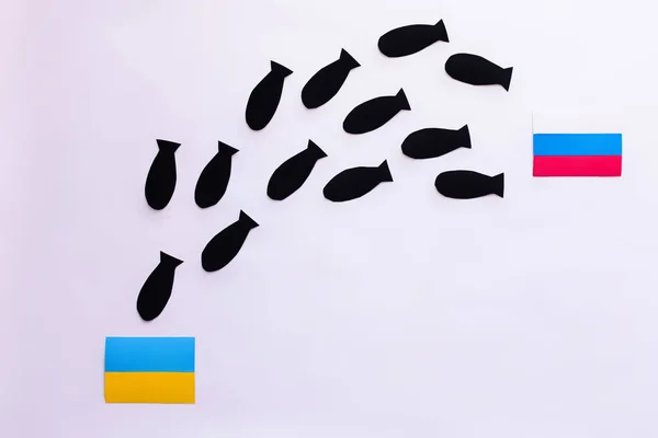 Top view of paper bombs between ukrainian and russian flags on white background — Stock Photo