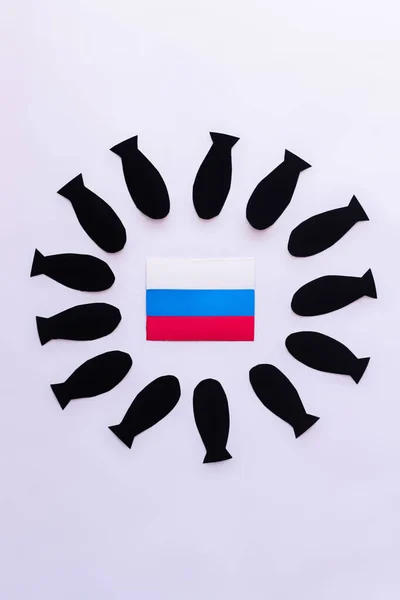 Vue du dessus du drapeau russe dans le cadre des bombes en papier sur fond blanc — Photo de stock