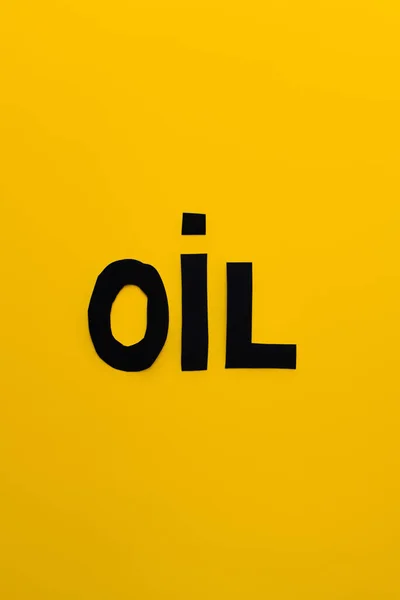 Top view of paper oil word on yellow background — Stock Photo