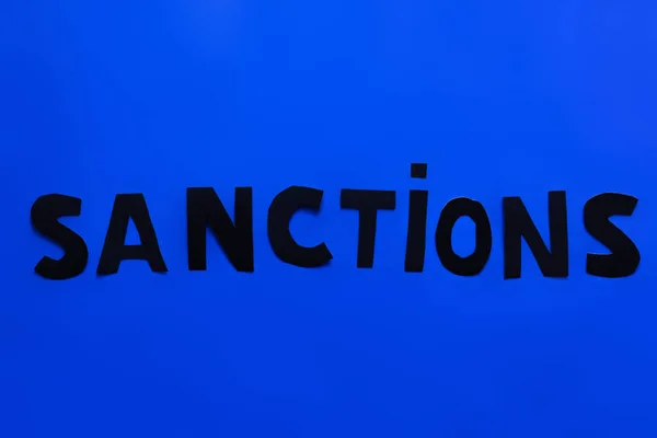 Vista superior de las sanciones sobre fondo azul - foto de stock