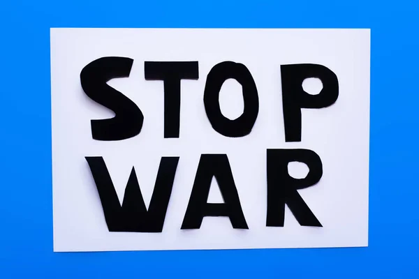 Vista superior de las letras stop war sobre fondo blanco y azul - foto de stock