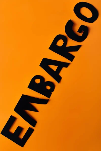 Top view of embargo lettering on orange background with copy space — Stock Photo
