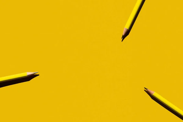 Vue de dessus des crayons acérés sur fond jaune — Photo de stock