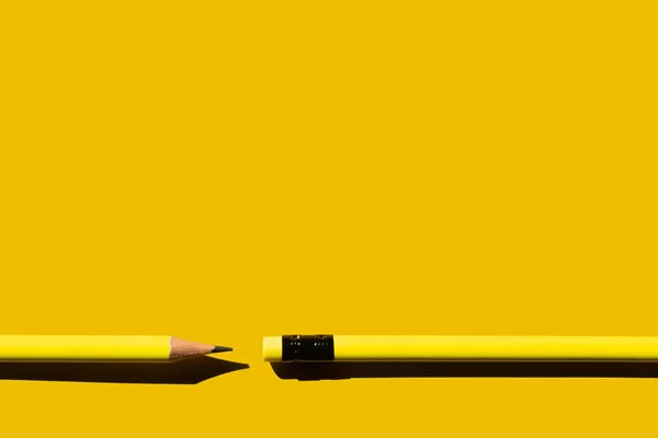 Top view of sharp pencils and eraser on yellow background — стоковое фото