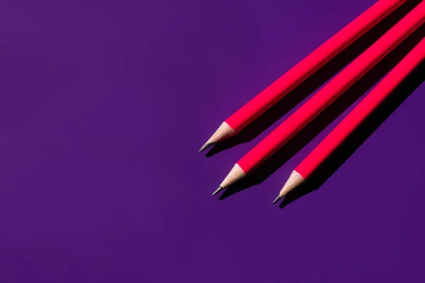 Вид сверху на острые карандаши на фиолетовом фоне — стоковое фото