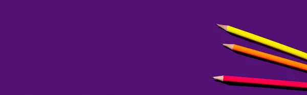 Vista superior de lápices de colores sobre fondo púrpura, bandera - foto de stock