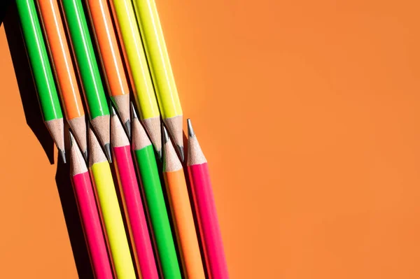 Vue de dessus des crayons colorés sur fond orange — Photo de stock