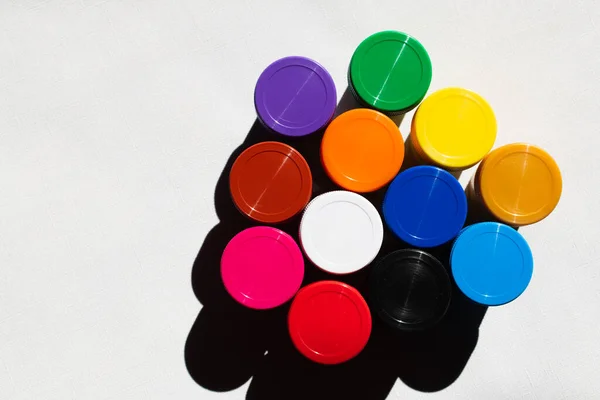 Top view of jars with colorful paint on white — Stock Photo