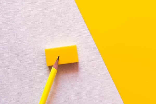 Vista superior do lápis na borracha no branco e no amarelo — Fotografia de Stock