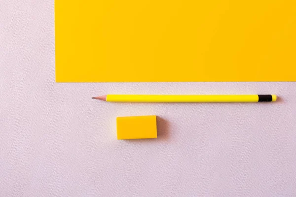 Верхний вид карандаша рядом с ластиком на белом и желтом — стоковое фото
