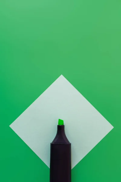 Вид зверху маркерної ручки на паперовій ноті на зеленому — стокове фото