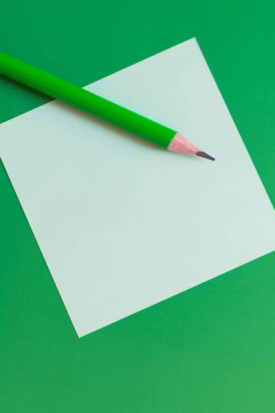 Vista superior do lápis na nota de papel no verde — Fotografia de Stock