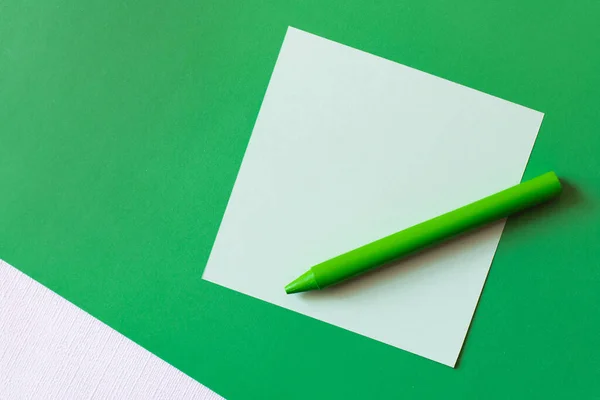 Top view of crayon near paper note on green — Stock Photo