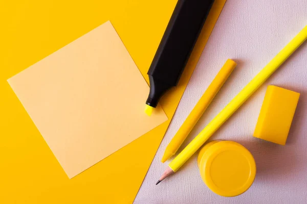 Top view of stationery and marker pen near paper note on textured white and yellow — стоковое фото