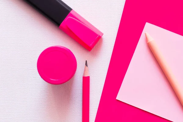 Top view of stationery and jar with paint near paper note on textured white and pink — Stock Photo