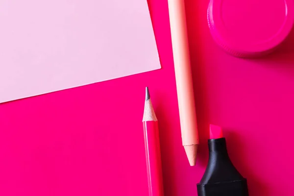 Top view of stationery and jar with paint near paper note on pink — Stock Photo