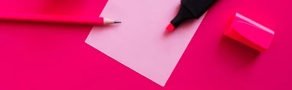 Top view of stationery near blank paper note on pink, banner — стоковое фото