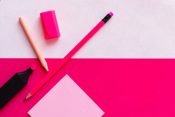 Top view of stationery near jar with paint and empty paper note on textured white and pink — Stock Photo