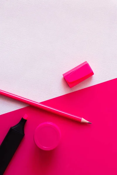 Vue du dessus du stylo marqueur et du crayon près du pot avec peinture sur blanc et rose texturé — Photo de stock