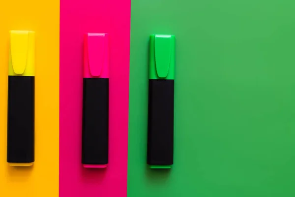 Flat lay de canetas marcadores coloridos em fundo multicolorido — Fotografia de Stock