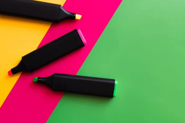 Вид зверху барвисті маркерні ручки на різнокольоровому фоні — стокове фото