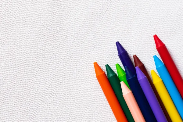 Vue de dessus de l'ensemble avec des crayons colorés sur fond blanc texturé — Photo de stock