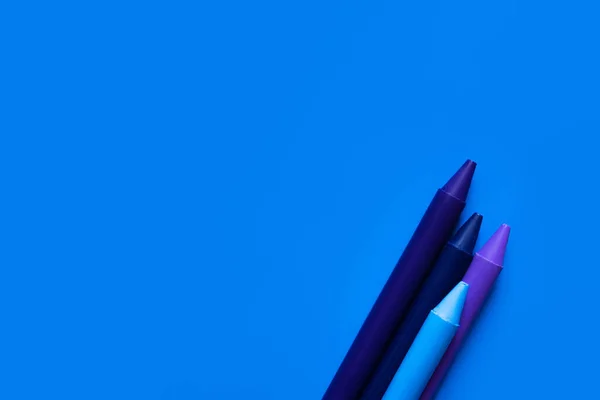 Top view of gradient crayons on bright blue background — Stock Photo