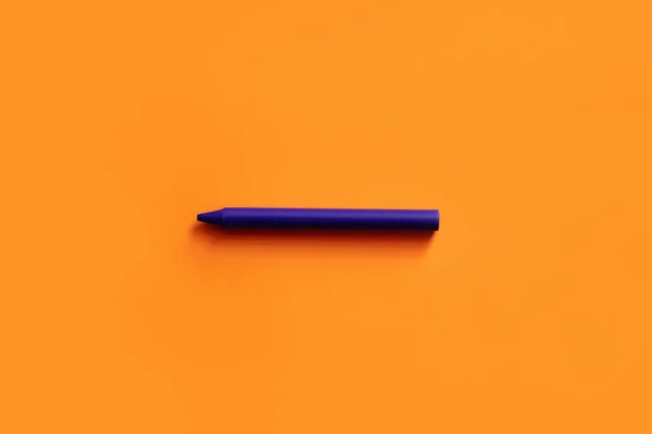 Top view of purple crayon on orange background — Stock Photo