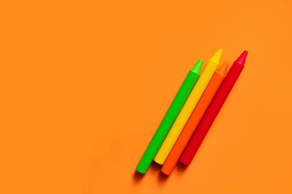 Top view of colorful crayons on orange background — Stock Photo