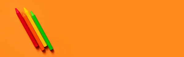 Top view of colorful crayons on orange background, banner — стоковое фото