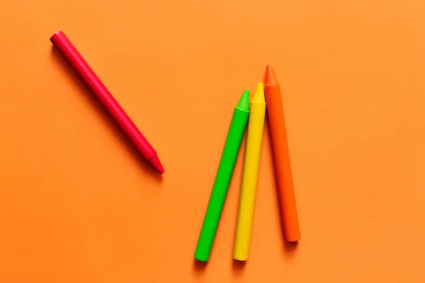 Top view of set with colorful crayons on orange background — стоковое фото