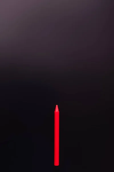 Top view of red crayon on black background — Stock Photo