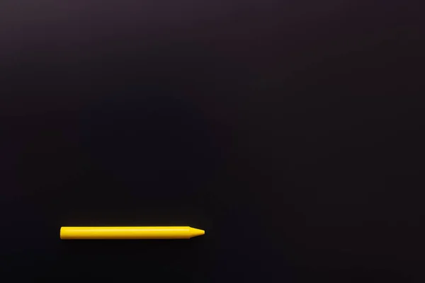 Top view of yellow crayon on black background — Stock Photo