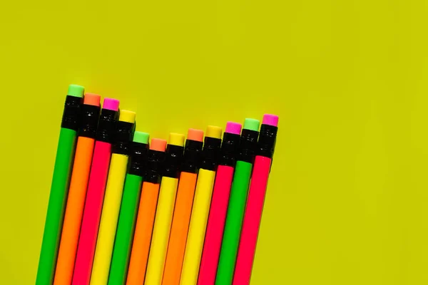 Top view of pencils with erasers on green background — Stock Photo