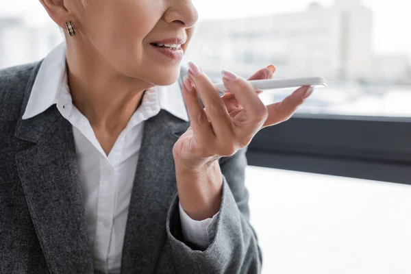 Partial view of economist sending voice message by mobile phone — Stock Photo