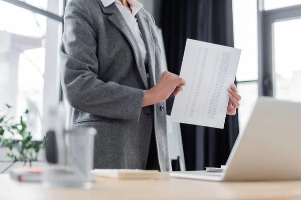 Partial view of banker holding document near laptop during online conference — Stockfoto