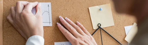 Partial view of blurred banker pinning paper notes on corkboard, banner — стоковое фото