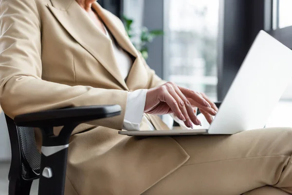 Cropped view of sitting economist in formal wear typing on laptop — Foto stock