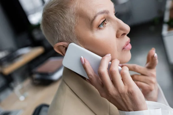 Nahaufnahme eines Ökonomen, der mit dem Finger zeigt, während er auf dem Smartphone spricht — Stockfoto