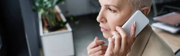 Banquier réfléchi détourner les yeux tout en parlant sur le téléphone mobile dans le bureau, bannière — Photo de stock