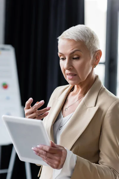 Discouraged businesswoman gesturing near digital tablet in office — Stock Photo