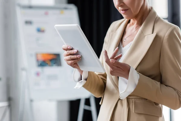 Cropped view of senior banker standing with digital tablet in office — Stock Photo