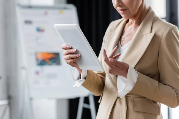 Ausgeschnittene Ansicht eines leitenden Bankers, der mit digitalem Tablet im Büro steht — Stockfoto